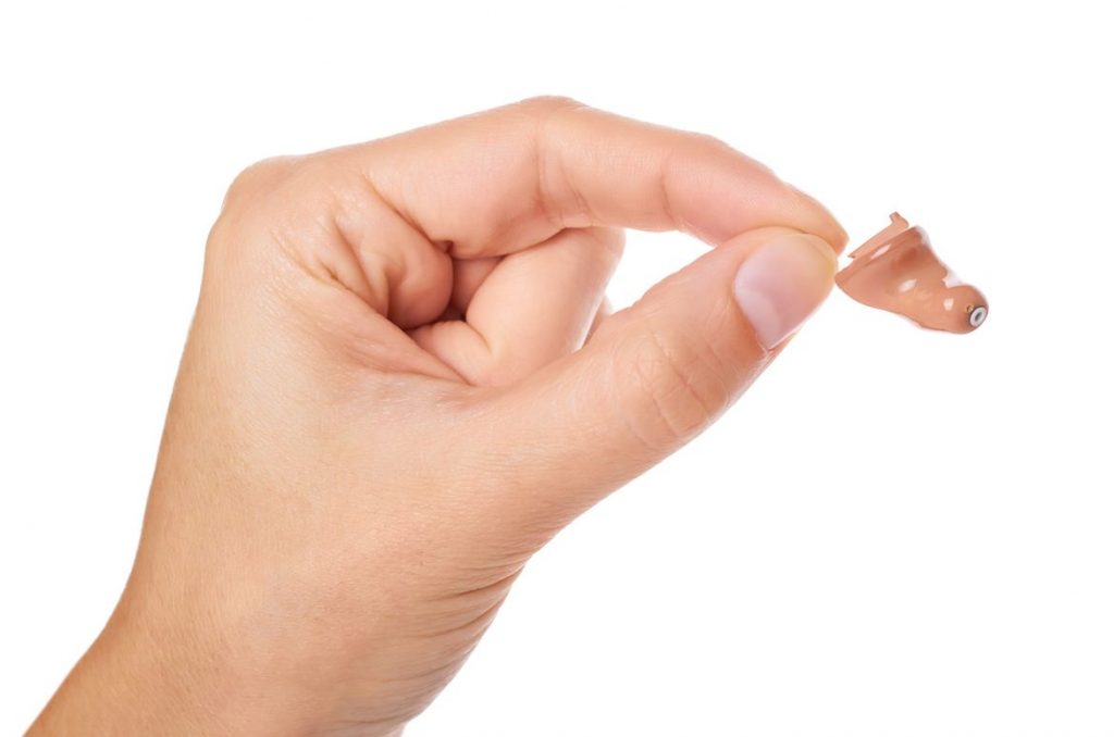 Hand holding hearing aid